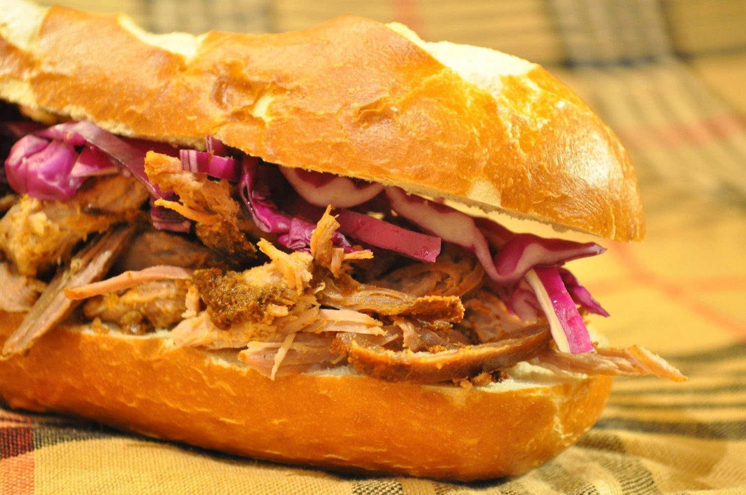 Pulled pork sandwich on plaid tablecloth